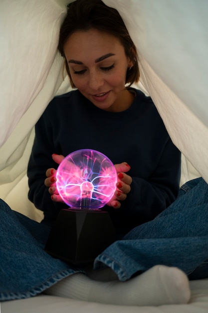 Mujer de vista frontal interactuando con una bola de plasma