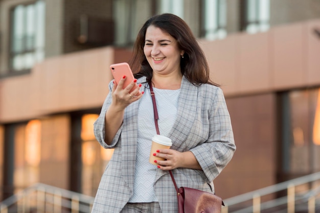 Mujer de vista frontal mirando su teléfono