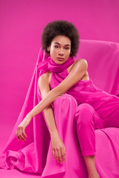 Mujer de vista frontal posando en traje rosa completo