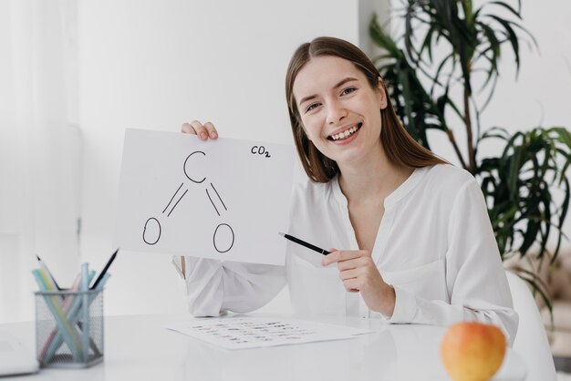 Mujer de vista frontal sosteniendo un dibujo de química