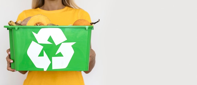 Mujer de vista frontal sosteniendo la papelera de reciclaje con espacio de copia