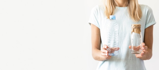 Mujer de vista frontal sosteniendo vasos de plástico con espacio de copia