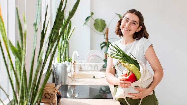 Foto gratuita mujer de vista frontal sosteniendo verduras orgánicas