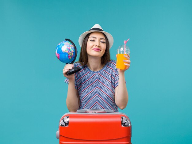 Mujer de vista frontal en vacaciones con jugo y globo sobre fondo azul viaje por mar viaje de verano viaje vacaciones