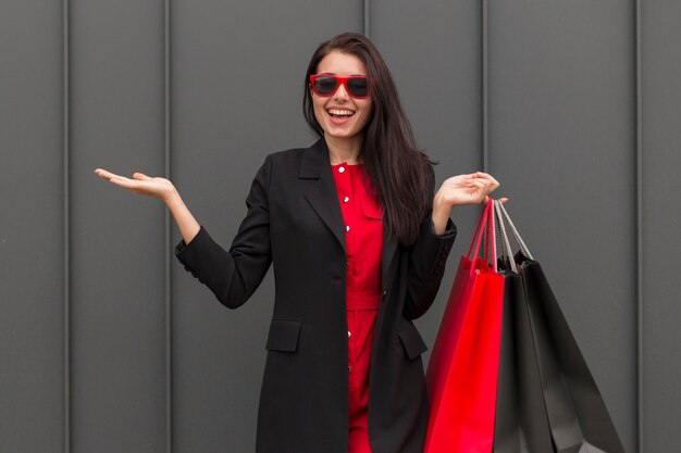 Mujer de vista frontal de ventas de viernes negro con bolsas de compras