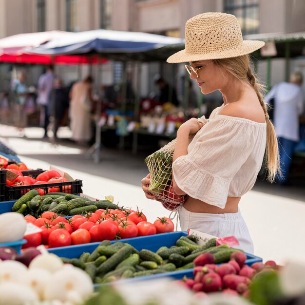 Mujer de vista lateral con bolsa orgánica para verduras