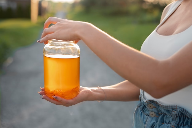 Foto gratuita mujer de vista lateral con deliciosa kombucha al aire libre