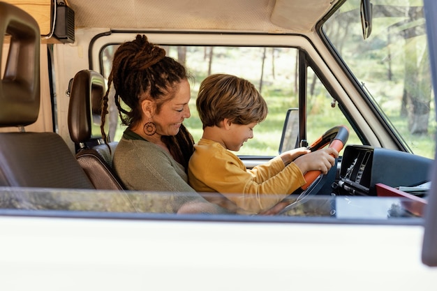 Mujer de vista lateral con hijo en su regazo conduciendo