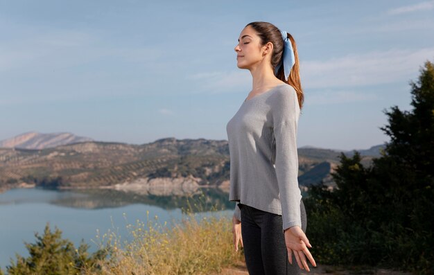 Mujer de vista lateral meditando en la naturaleza