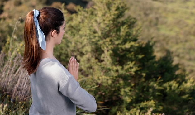 Mujer de vista lateral meditando en la naturaleza