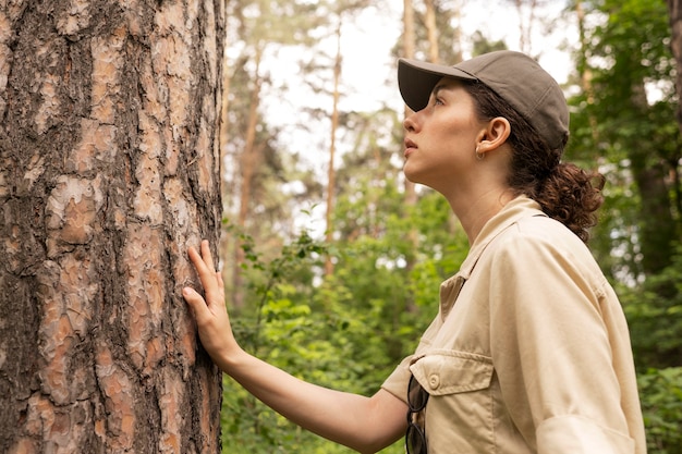 Foto gratuita mujer de vista lateral mirando el árbol