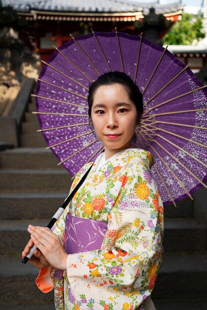 Mujer de vista lateral con paraguas wagasa