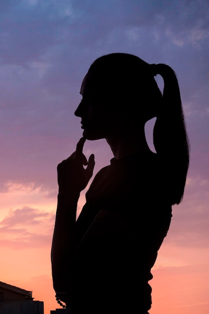 Mujer de vista lateral posando con fondo de cielo