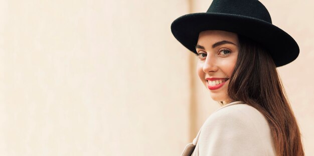 Mujer de vista lateral con un sombrero negro con espacio de copia