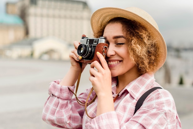 Mujer de vista lateral tomando una foto mientras viaja