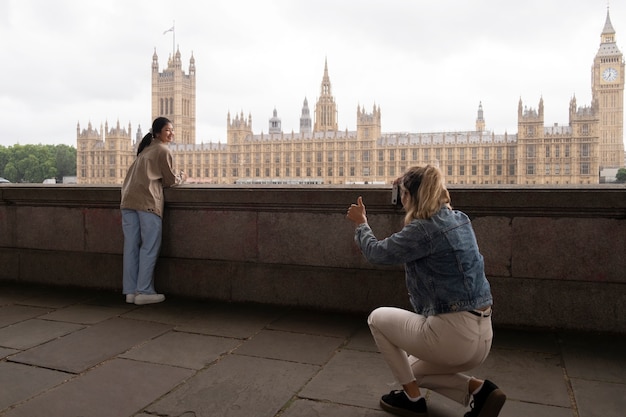 Mujer de vista lateral tomando fotos de un amigo