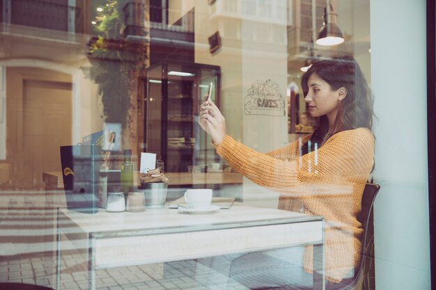 Mujer de vista lateral tomando selfie