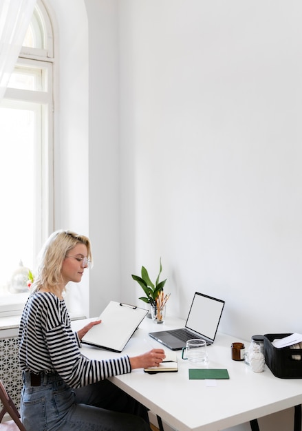 Foto gratuita mujer de vista lateral trabajando desde casa