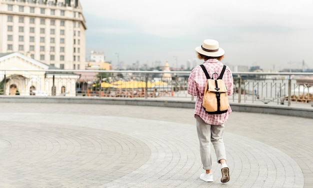 Mujer de vista posterior viajando a un nuevo lugar con espacio de copia