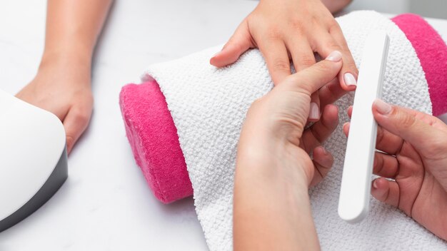 Mujer de vista superior haciendo la manicura de un cliente