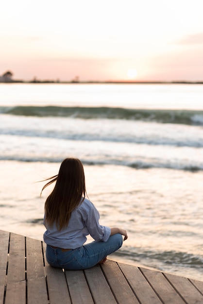 Foto gratuita mujer de vista trasera meditando al aire libre