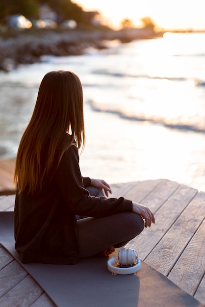 Mujer de vista trasera meditando fuera