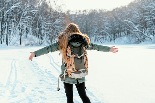 Mujer de vista trasera con mochila en día de invierno