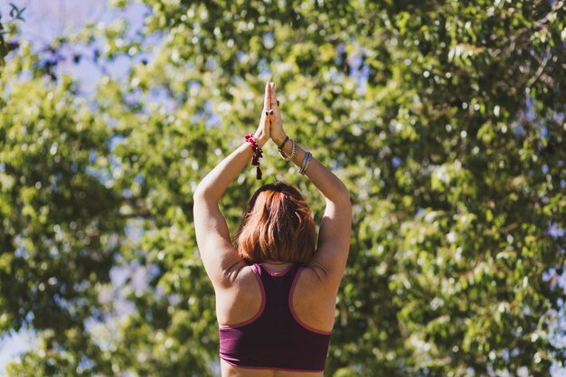 Mujer de vista trasera en pose de árbol