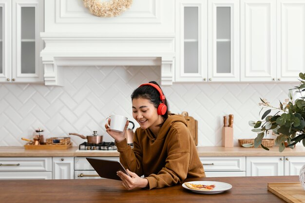 Mujer vistiendo auriculares y mirando tablet