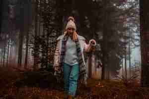 Foto gratuita mujer vistiendo gorro de lana marrón en el bosque