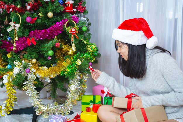 Mujer vistiendo gorro de navidad feliz con regalo de navidad
