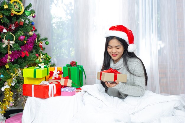 Mujer vistiendo gorro de navidad feliz con regalo de navidad