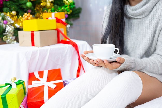 Mujer vistiendo gorro de navidad feliz con regalo de navidad