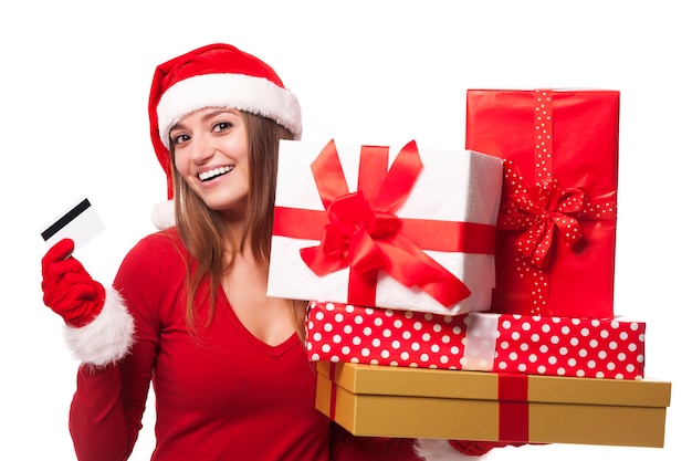 Mujer vistiendo gorro de Papá Noel con regalos de Navidad y tarjeta de crédito