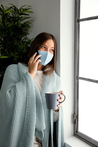 Mujer vistiendo mascarilla en casa