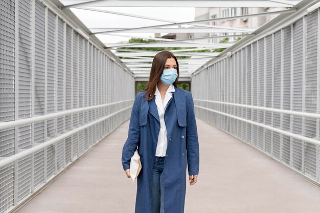 Foto gratuita mujer vistiendo mascarilla de tiro medio