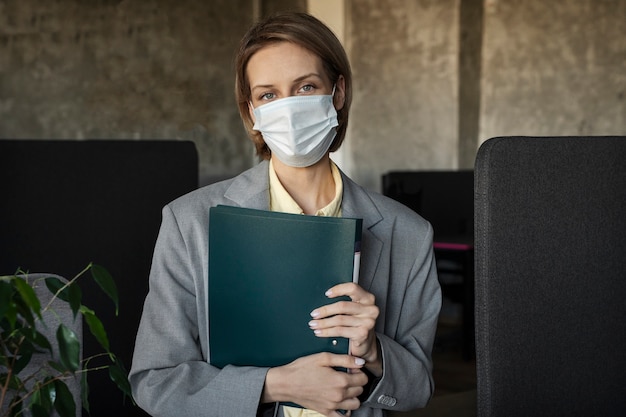 Foto gratuita mujer vistiendo mascarilla de tiro medio