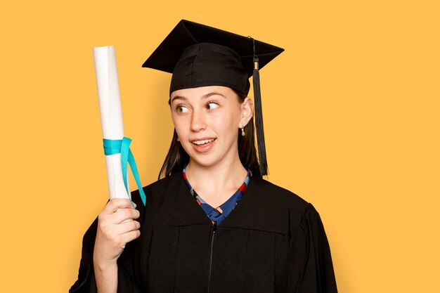 Mujer vistiendo regalia sosteniendo su título de graduación