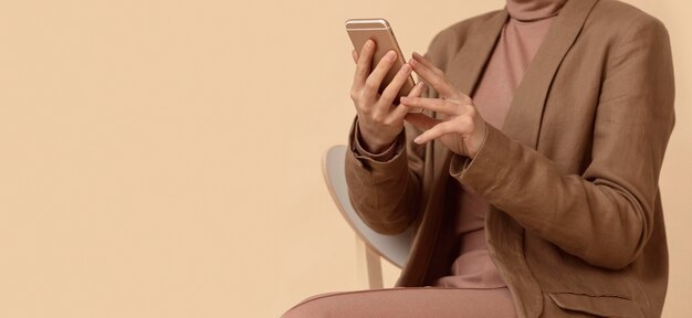 Mujer vistiendo ropa de negocios mediante teléfono móvil