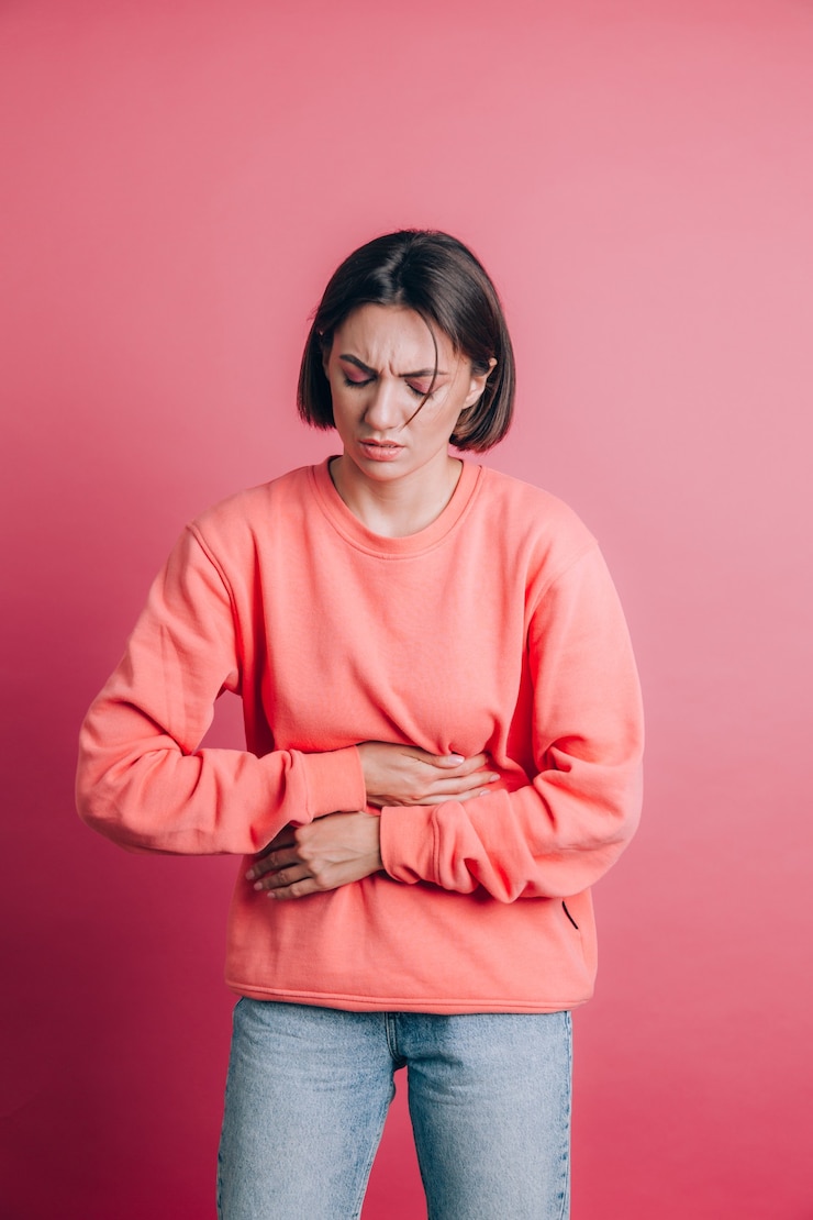 Foto gratuito mujer vistiendo un suéter casual en el fondo que sufre dolor de estómago con muecas dolorosas, sintiendo calambres repentinos, concepto de ginecología