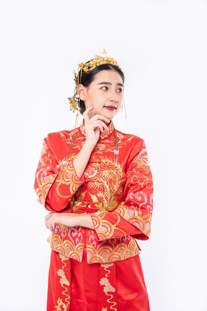 Mujer vistiendo traje Cheongsam es una sesión de fotos para promover las compras de los viajeros de eventos en el año nuevo chino