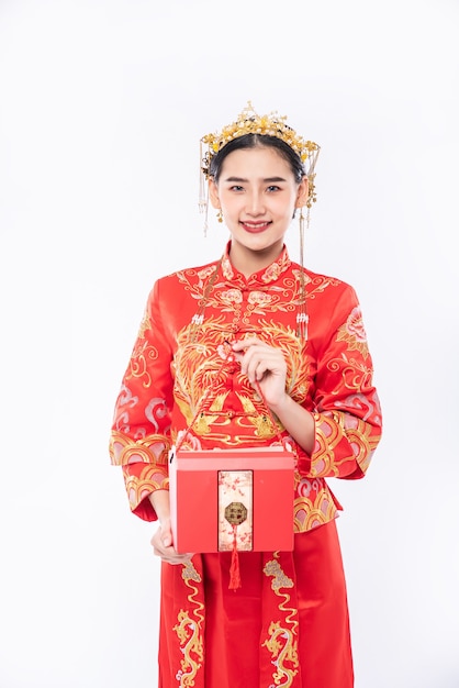 Mujer vistiendo traje Cheongsam listo para regalar bolsa roja a hermana para sorprender en día tradicional