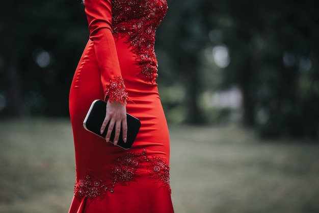 Mujer vistiendo un vestido ajustado sexy rojo y sosteniendo un bolso