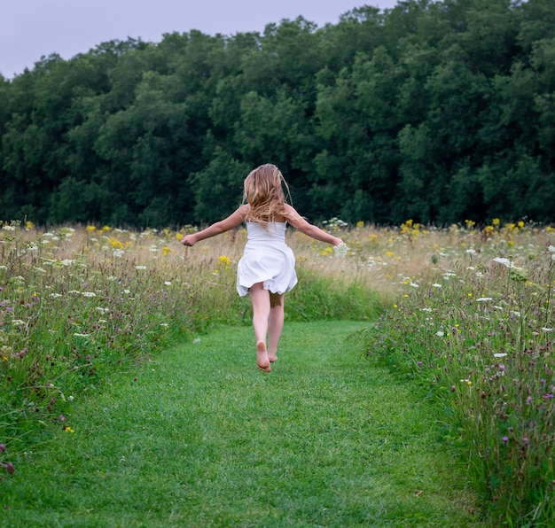 Mujer vistiendo un vestido y corriendo por un campo