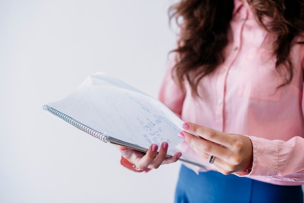 Foto gratuita mujer volteando página en el cuaderno en el estudio