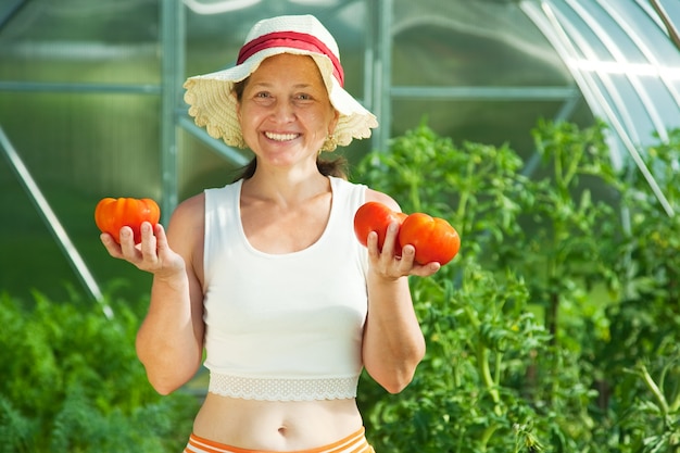 Mujer witrh tomate en invernadero