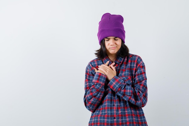 Mujercita cogidos de la mano en el gorro de pecho mirando esperanzado