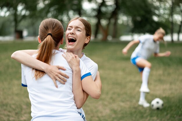 Mujeres abrazándose en el campo de fútbol