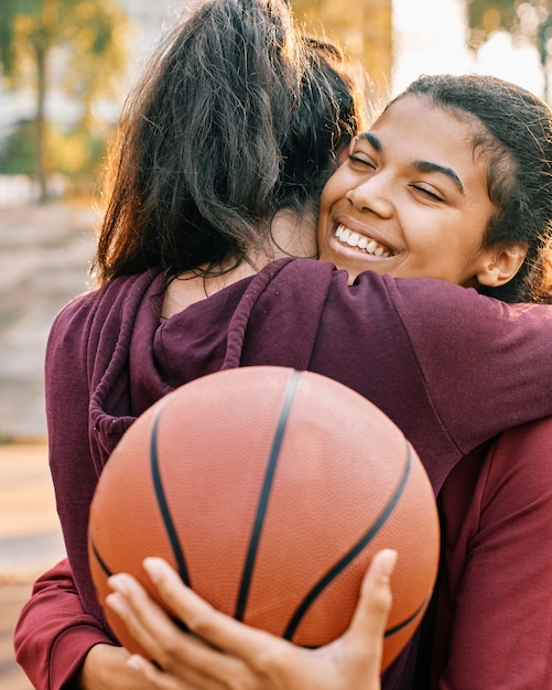 Foto gratuita mujeres abrazándose después de un partido de baloncesto