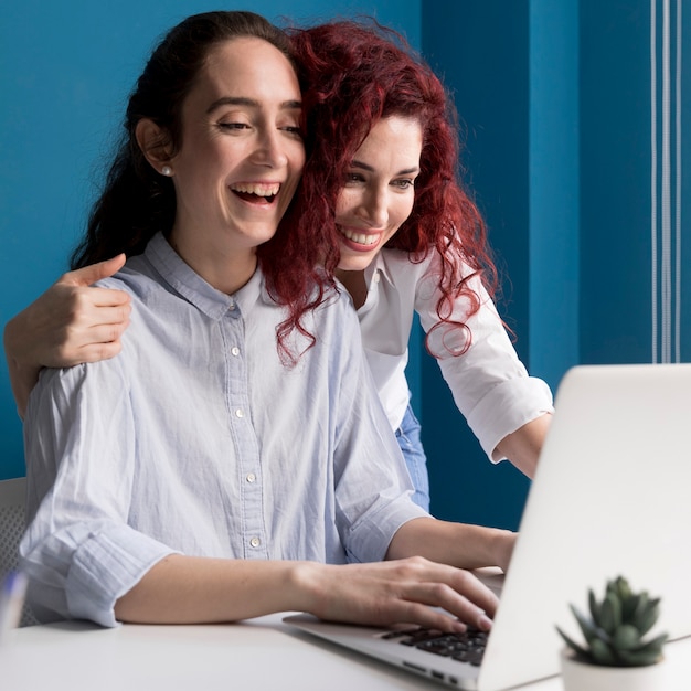 Foto gratuita mujeres adultas felices trabajando juntas